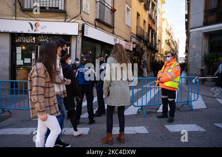 Die Polizei kontrolliert den Zugang zu El Rastro de Madrid, das am 22. November 2020 in Madrid, Spanien, mit der Hälfte der Sitze und der Kapazität nach acht Monaten, die aufgrund der COVID-19-Pandemie ausgesetzt wurden, wieder eröffnet wird. (Foto von Jon Imanol Reino/NurPhoto) Stockfoto