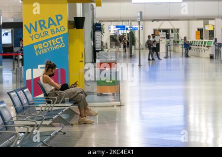 Passagiere, die mit den obligatorischen Gesichtsmasken in der Hauptabflugshalle im Terminal des internationalen Flughafens Athen ATH LGAV in Griechenland gesehen werden. In vielen Ländern Griechenlands wurden unter anderem Coronavirus-Maßnahmen wie Sperrung, Quarantäne und Reisebeschränkungen eingeführt. Passagiere, die Gesichtsmasken und Handschuhe tragen und Handdesinfektionsmittel als vorbeugende Maßnahme gegen die Ausbreitung der COVID-19-Pandemie verwenden. Griechenland und Europa schlossen die Grenzen für Menschen außerhalb Europas und der Schengen-Zone für eine lange Zeit, aber Griechenland begann mit der Aufhebung des Verkehrsverbots seit Juni 2020, um den Wirtschafts-, Reise- und Fremdenverkehr anzukurbeln Stockfoto