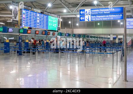 Passagiere, die mit den obligatorischen Gesichtsmasken in der Hauptabflugshalle im Terminal des internationalen Flughafens Athen ATH LGAV in Griechenland gesehen werden. In vielen Ländern Griechenlands wurden unter anderem Coronavirus-Maßnahmen wie Sperrung, Quarantäne und Reisebeschränkungen eingeführt. Passagiere, die Gesichtsmasken und Handschuhe tragen und Handdesinfektionsmittel als vorbeugende Maßnahme gegen die Ausbreitung der COVID-19-Pandemie verwenden. Griechenland und Europa schlossen die Grenzen für Menschen außerhalb Europas und der Schengen-Zone für eine lange Zeit, aber Griechenland begann mit der Aufhebung des Verkehrsverbots seit Juni 2020, um den Wirtschafts-, Reise- und Fremdenverkehr anzukurbeln Stockfoto