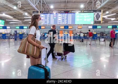 Passagiere, die mit den obligatorischen Gesichtsmasken in der Hauptabflugshalle im Terminal des internationalen Flughafens Athen ATH LGAV in Griechenland gesehen werden. In vielen Ländern Griechenlands wurden unter anderem Coronavirus-Maßnahmen wie Sperrung, Quarantäne und Reisebeschränkungen eingeführt. Passagiere, die Gesichtsmasken und Handschuhe tragen und Handdesinfektionsmittel als vorbeugende Maßnahme gegen die Ausbreitung der COVID-19-Pandemie verwenden. Griechenland und Europa schlossen die Grenzen für Menschen außerhalb Europas und der Schengen-Zone für eine lange Zeit, aber Griechenland begann mit der Aufhebung des Verkehrsverbots seit Juni 2020, um den Wirtschafts-, Reise- und Fremdenverkehr anzukurbeln Stockfoto