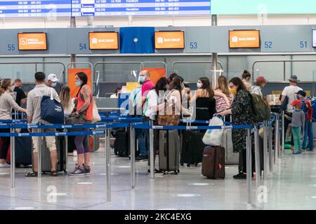 Passagiere, die mit den obligatorischen Gesichtsmasken in der Hauptabflugshalle im Terminal des internationalen Flughafens Athen ATH LGAV in Griechenland gesehen werden. In vielen Ländern Griechenlands wurden unter anderem Coronavirus-Maßnahmen wie Sperrung, Quarantäne und Reisebeschränkungen eingeführt. Passagiere, die Gesichtsmasken und Handschuhe tragen und Handdesinfektionsmittel als vorbeugende Maßnahme gegen die Ausbreitung der COVID-19-Pandemie verwenden. Griechenland und Europa schlossen die Grenzen für Menschen außerhalb Europas und der Schengen-Zone für eine lange Zeit, aber Griechenland begann mit der Aufhebung des Verkehrsverbots seit Juni 2020, um den Wirtschafts-, Reise- und Fremdenverkehr anzukurbeln Stockfoto