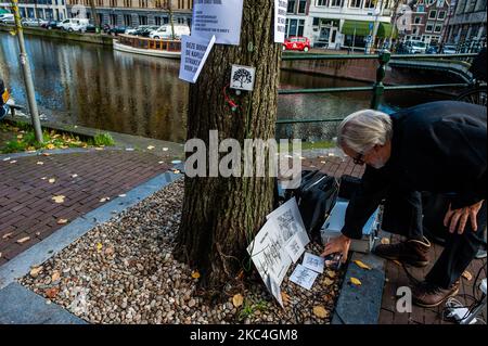 Der niederländische Künstler und Musiker Bert Barten produziert Musik, indem er ein Audiosystem an den Baum und von dort an seinen Computer anbringt, während der musikalischen Proteste gegen den Baumschnitt im Zentrum von Amsterdam am 23.. November 2020. (Foto von Romy Arroyo Fernandez/NurPhoto) Stockfoto