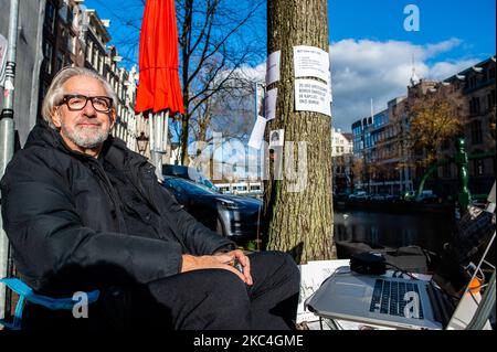 Der niederländische Künstler und Musiker Bert Barten produziert Musik, indem er ein Audiosystem an den Baum und von dort an seinen Computer anbringt, während der musikalischen Proteste gegen den Baumschnitt im Zentrum von Amsterdam am 23.. November 2020. (Foto von Romy Arroyo Fernandez/NurPhoto) Stockfoto