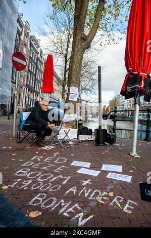 Der niederländische Künstler und Musiker Bert Barten produziert Musik, indem er ein Audiosystem an den Baum und von dort an seinen Computer anbringt, während der musikalischen Proteste gegen den Baumschnitt im Zentrum von Amsterdam am 23.. November 2020. (Foto von Romy Arroyo Fernandez/NurPhoto) Stockfoto