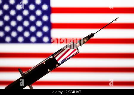 Die medizinische Spritze ist mit einer amerikanischen Flagge im Hintergrund auf diesem Bild zu sehen, das am 23. November 2020 in Polen aufgenommen wurde. (Foto von Jakub Porzycki/NurPhoto) Stockfoto