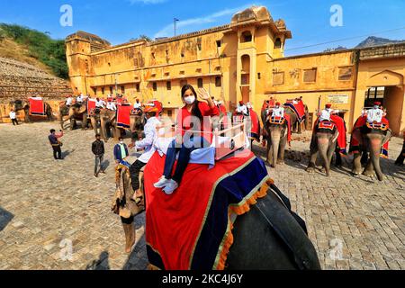 Touristen nehmen Elefantenritt im historischen Amer Fort nach Wiederaufnahme des Dienstes nach über 8 Monaten Aussetzung aufgrund der COVID-19 Pandemie, in Jaipur, Rajasthan, Indien, Dienstag, 24. November 2020. (Foto von Vishal Bhatnagar/NurPhoto) Stockfoto