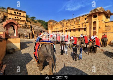 Touristen nehmen Elefantenritt im historischen Amer Fort nach Wiederaufnahme des Dienstes nach über 8 Monaten Aussetzung aufgrund der COVID-19 Pandemie, in Jaipur, Rajasthan, Indien, Dienstag, 24. November 2020. (Foto von Vishal Bhatnagar/NurPhoto) Stockfoto