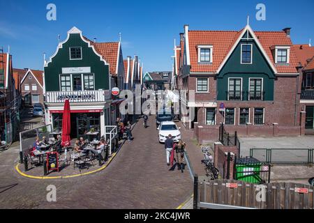 Alltag in Volendam Traditionelles Fischerdorf mit holländischer Architektur in Nordholland in der Nähe von Amsterdam in den Niederlanden. Volendam hat einen Hafen und ist ein beliebtes Ziel und Touristenattraktion im Land. Es gibt alte Fischerboote, traditionelle Kleidung der Einheimischen, Fährfahrt nach Marken, Museen, Käsefaktroy, Cafe und Souvenirläden am Wasser und einen kleinen Strand. Es gibt Häuser entlang der Küste und einen Yachthafen in der Nähe für Touristen und Einheimische als Besucher, so dass der Tourismus das Haupteinkommen für die Gemeinde ist. Volendam wurde in vielen aktuellen Filmen gezeigt. Volendam - Die Niederlande Stockfoto