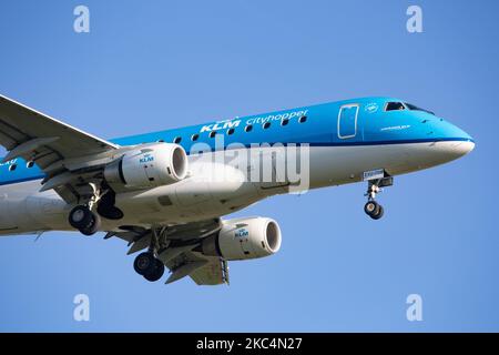 Ein Regionalflugzeug des Typs KLM Cityhopper Embraer ERJ-175, das bei einem endgültigen Anflug und einer Landung auf dem internationalen Flughafen Amsterdam Schiphol AMS EHAM während eines klaren blauen Himmels gesehen wurde. Die brasilianische Schmalkarosserie E170 / E175 Passagierflugzeug hat die Registrierung PH-EXU. KLM Royal Dutch Airlines oder Koninklijke Luchtvaart Maatschappij ist die Flaggschiff-Fluggesellschaft der Niederlande und die älteste Fluggesellschaft der Welt mit einer Flotte von 115 Flugzeugen. Die Fluggesellschaft hat einen Stab und hat ihren Sitz am Flughafen Amsterdam Schiphol und ist Mitglied der SkyTeam-Luftfahrtallianz-Gruppe. Der weltweite Personenverkehr ging im Laufe der Zeit zurück Stockfoto