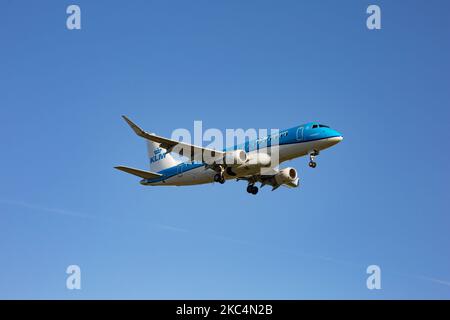 Ein Regionalflugzeug des Typs KLM Cityhopper Embraer ERJ-175, das bei einem endgültigen Anflug und einer Landung auf dem internationalen Flughafen Amsterdam Schiphol AMS EHAM während eines klaren blauen Himmels gesehen wurde. Die brasilianische Schmalkarosserie E170 / E175 Passagierflugzeug hat die Registrierung PH-EXU. KLM Royal Dutch Airlines oder Koninklijke Luchtvaart Maatschappij ist die Flaggschiff-Fluggesellschaft der Niederlande und die älteste Fluggesellschaft der Welt mit einer Flotte von 115 Flugzeugen. Die Fluggesellschaft hat einen Stab und hat ihren Sitz am Flughafen Amsterdam Schiphol und ist Mitglied der SkyTeam-Luftfahrtallianz-Gruppe. Der weltweite Personenverkehr ging im Laufe der Zeit zurück Stockfoto