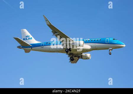 Ein Regionalflugzeug des Typs KLM Cityhopper Embraer ERJ-175, das bei einem endgültigen Anflug und einer Landung auf dem internationalen Flughafen Amsterdam Schiphol AMS EHAM während eines klaren blauen Himmels gesehen wurde. Die brasilianische Schmalkarosserie E170 / E175 Passagierflugzeug hat die Registrierung PH-EXU. KLM Royal Dutch Airlines oder Koninklijke Luchtvaart Maatschappij ist die Flaggschiff-Fluggesellschaft der Niederlande und die älteste Fluggesellschaft der Welt mit einer Flotte von 115 Flugzeugen. Die Fluggesellschaft hat einen Stab und hat ihren Sitz am Flughafen Amsterdam Schiphol und ist Mitglied der SkyTeam-Luftfahrtallianz-Gruppe. Der weltweite Personenverkehr ging im Laufe der Zeit zurück Stockfoto