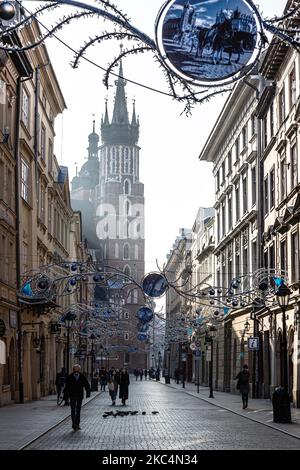 Passanten in Schutzmasken werden auf der Florianska Straße am Hauptmarkt in der Krakauer Altstadt gesehen, während die Stadt unter teilweiser Coronavirus-Sperre neue Weihnachtsdekorationen anzieht, 26. November 2020. Die Altstadt von Krakau ist in der Regel sehr voll mit Touristen, nicht es bleibt weitgehend verlassen wegen Covid-19 Einschränkungen. (Foto von Dominika Zarzycka/NurPhoto) Stockfoto