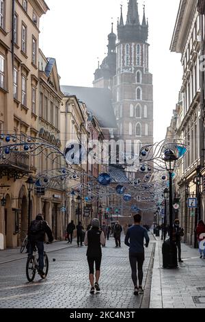 Passanten in Schutzmasken werden auf der Florianska Straße am Hauptmarkt in der Krakauer Altstadt gesehen, während die Stadt unter teilweiser Coronavirus-Sperre neue Weihnachtsdekorationen anzieht, 26. November 2020. Die Altstadt von Krakau ist in der Regel sehr voll mit Touristen, nicht es bleibt weitgehend verlassen wegen Covid-19 Einschränkungen. (Foto von Dominika Zarzycka/NurPhoto) Stockfoto