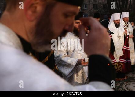 Priester verschiedener christlicher Konfessionen feiern einen Gedenkgottesdienst, während Menschen während der Trauerveranstaltung in Kiew, Ukraine, am 28. November Kerzen anzünden und Blumensträuße aus den Ohren und aus dem arrowwood zum Denkmal der großen Hungeropfer legen. 2020.die Ukraine ehrt das Gedenken an die Opfer der Hungersnöte und der Großen Hungersnot (Holodomor) von 1932 bis 1933, als 4,5 Millionen Ukrainer, darunter 600.000 ungeborene Kinder, vom sowjetischen Regime unter Joseph Stalin verhungert wurden. (Foto von Sergii Chartschenko/NurPhoto) Stockfoto