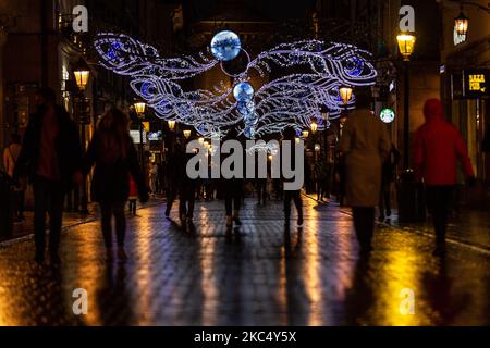 Passanten in schützenden Gesichtsmasken werden an einem kalten Winterabend in der Florianska Straße am Hauptmarkt in der Krakauer Altstadt gesehen, als die Stadt unter teilweiser Coronavirus-Sperre neue Weihnachtslichter aufstellte, Krakau, Polen, 29. November 2020. Die Altstadt von Krakau ist in der Regel sehr voll mit Touristen, jetzt bleibt es weitgehend verlassen wegen Covid-19 Einschränkungen. (Foto von Dominika Zarzycka/NurPhoto) Stockfoto