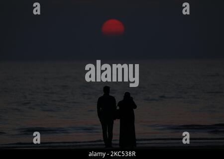 Ein Paar beobachtet am 28. November 2020 die Schönheit des Sonnenuntergangs am Strand von Kuakata in Patuakhali, Bangladesch. (Foto von Ahmed Salahuddin/NurPhoto) Stockfoto