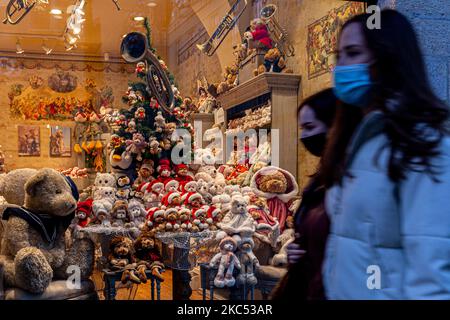 Passanten in schützenden Gesichtsmasken werden an einem kalten Winterabend in der Florianska-Straße am Hauptmarkt in der Krakauer Altstadt an einem Schaufenster mit Weihnachtsschmuck gesehen, während sich die Stadt inmitten einer teilweisen Sperrung durch das Coronavirus auf Weihnachten vorbereitet, 1. Dezember 2020, Krakau, Polen. Die Altstadt von Krakau ist in der Regel sehr voll mit Touristen, jetzt bleibt es weitgehend verlassen wegen Covid-19 Einschränkungen. (Foto von Dominika Zarzycka/NurPhoto) Stockfoto