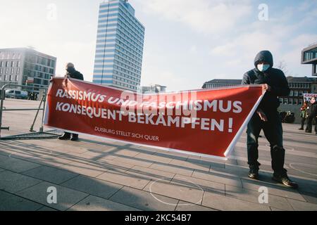 Zwei Männer von Gegendemonstranten halten am 29. November 2020 im Duisburger Hauptbahnhof das Transparent „Kampf gegen Rassismus und Facismus“. (Foto von Ying Tang/NurPhoto) Stockfoto