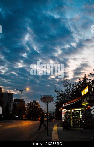 Ein Mann mit einer schützenden Gesichtsmaske überquert eine Straße, während Wolken den Himmel in den Abendstunden am 3. Dezember 2020 in Ankara, Türkei, bedecken. (Foto von Altan Gocher/NurPhoto) Stockfoto