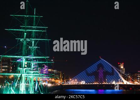 Beleuchtet das Jeanie Johnston Schiff und Dublins Samuel Beckett Bridge, ein Teil des ‘Winter Lights’ Projekts, animiert mit ‘Keep on Moving’ von Richmond Barracks über 55s Bewegungsgruppe: Ein maßgeschneiderter vierminütiger Tanz rund um die Themen Stärke, Belastbarkeit und Spaß. Vom 1.. Dezember bis zum 1.. Januar werden 17 Orte in der ganzen Stadt mit farbenfrohen Projektionen und Lichtvorführungen verwandelt. Am Donnerstag, den 3. Dezember 2020, in Dublin, Irland. (Foto von Artur Widak/NurPhoto) Stockfoto