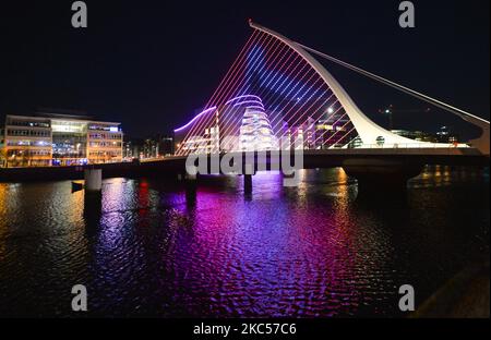 Beleuchtetes Dublins Convention Center und Samuel Beckett Bridge, ein Teil des ‘Winter Lights’ Projekts, animiert mit ‘Keep on Moving’ von Richmond Barracks über 55s Movement Group: Ein maßgeschneiderter vierminütiger Tanz zu den Themen Stärke, Belastbarkeit und Spaß. Vom 1.. Dezember bis zum 1.. Januar werden 17 Orte in der ganzen Stadt mit farbenfrohen Projektionen und Lichtvorführungen verwandelt. Am Donnerstag, den 3. Dezember 2020, in Dublin, Irland. (Foto von Artur Widak/NurPhoto) Stockfoto