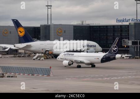 Lufthansa Airbus A380 Doppeldeckerflugzeug, gesehen neben einem kleineren Airbus A320 in Frankfurt der FRA-Flughafen dockte an den Gates an und wurde mit Passagier und Fracht für einen Langstreckenflug beladen. Das Großkarosserie-Flugzeug A380-800 trägt die Registrierung D-AIMM den Namen Delhi und wird von 4x RR-Triebwerken angetrieben. Die Deutsche Lufthansa AG DLH oder LH ist die größte Airline Deutschlands mit Drehkreuz in Frankfurt, München und den Flughäfen Berlin, ehemalige deutsche Flaggenfluggesellschaft und Gründungsmitglied der Star Alliance Airline Aviation Group. Der weltweite Passagierverkehr ging während der Coronavirus-Covid-19-Pandemie zurück Stockfoto