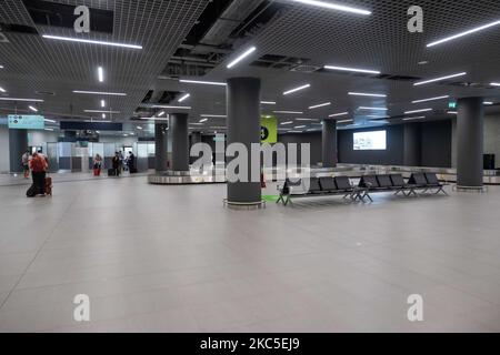 Das Innere des neuen Terminals des internationalen Flughafens Thessaloniki Makedonia SKG LGTS. Der neu errichtete und eröffnete Gepäckbandbereich, die Ankunftshalle des zweiten Terminals, das nach der Privatisierung von Fraport Greece, dem Betreiber des Flughafens, gebaut wurde. Am Gepäckabholbereich werden ankommende Passagiere von Inlandsflügen mit Gesichtsmask aufgrund der Sicherheitsmaßnahmen des Coronavirus gesehen. Der weltweite Personenverkehr ging während der Pandemie des Coronavirus Covid-19 zurück, und die Industrie kämpfte ums Überleben. Im Moment erlaubt die Regierung mit einem NOTAM nur das wesentliche Reisen als Stockfoto