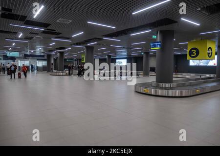 Das Innere des neuen Terminals des internationalen Flughafens Thessaloniki Makedonia SKG LGTS. Der neu errichtete und eröffnete Gepäckbandbereich, die Ankunftshalle des zweiten Terminals, das nach der Privatisierung von Fraport Greece, dem Betreiber des Flughafens, gebaut wurde. Am Gepäckabholbereich werden ankommende Passagiere von Inlandsflügen mit Gesichtsmask aufgrund der Sicherheitsmaßnahmen des Coronavirus gesehen. Der weltweite Personenverkehr ging während der Pandemie des Coronavirus Covid-19 zurück, und die Industrie kämpfte ums Überleben. Im Moment erlaubt die Regierung mit einem NOTAM nur das wesentliche Reisen als Stockfoto