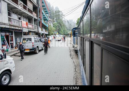 Der Zug fährt neben den Häusern und der Straße. Die Darjeeling Himalayan Railway oder DHR oder bekannt als Toy Train wegen der engen 2ft Gauge auf den Hängen des Himalaya in Indien. Der Zug verkehrt zwischen New Jalpaiguri und Darjeeling in Westbengalen, erbaut 1881 und erreicht eine Höhe von 2200m. Über dem Meeresspiegel. Die Lokomotive verwendet Diesel, aber auch Dampflokomotiven der B-Klasse kommen zum Einsatz und pendeln Einheimische und Touristen von Ghum nach Darjeeling auf einer Strecke mit Panoramablick auf die Berge, die Pisten, die Teeplantage und den Pass von den Städten neben den Häusern und Märkten. Seit 1999 UNE Stockfoto