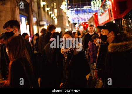 Einkäufer, die zum Teil Gesichtsmasken tragen, gehen am 12. Dezember 2020 durch einen geschäftigen Oxford Circus in London, England. Die Spekulationen, dass London unter die „Tier 3“-Einschränkungen des Coronavirus fallen könnte, haben diese Woche zugenommen, angesichts steigender Zahlen von Menschen, die in der Stadt positiv auf Covid-19 getestet wurden. Im Rahmen von Tier 3 würde das Gastgewerbe nur wenige Wochen nach der Wiedereröffnung am Ende der zweiten nationalen Sperre am 2. Dezember wieder schließen müssen, außer als Imbiss zu agieren. Die Entscheidung soll am kommenden Mittwoch auf einer Sitzung getroffen werden, die angeblich vom britischen Premierminister Bor geleitet werden soll Stockfoto