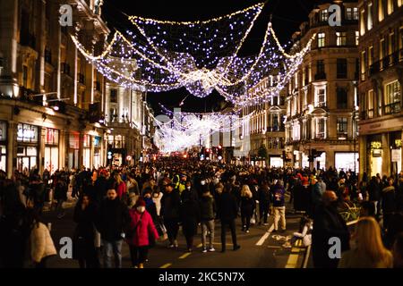 Einkäufer, die teilweise Gesichtsmasken tragen, gehen am 12. Dezember 2020 in der geschäftigen Regent Street in London, England, unter Weihnachtsschmuck. Die Spekulationen, dass London unter die „Tier 3“-Einschränkungen des Coronavirus fallen könnte, haben diese Woche zugenommen, angesichts steigender Zahlen von Menschen, die in der Stadt positiv auf Covid-19 getestet wurden. Im Rahmen von Tier 3 würde das Gastgewerbe nur wenige Wochen nach der Wiedereröffnung am Ende der zweiten nationalen Sperre am 2. Dezember wieder schließen müssen, außer als Imbiss zu agieren. Die Entscheidung soll am kommenden Mittwoch auf einer Sitzung getroffen werden, die angeblich von der Leitung von „Bbrücke“ geleitet werden soll Stockfoto