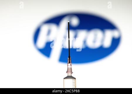 Foto-Illustration einer medizinischen Spritze mit einer Nadel, die vor dem Logo des Pharmakonzerns von Pfizer zu sehen ist. Großbritannien hat den Pfizer/BioNTech-Impfstoff zugelassen und eingeführt, während die FDA den COVID-19-Impfstoff für den Notfall in den USA zugelassen hat, wie von amerikanischen Medien berichtet wurde. Die Coronavirus-Pandemie, eine der größten Gesundheitskrisen der Welt, wird zu dem größten Impfprogramm in der menschlichen Geschichte führen. Amsterdam, Niederlande am 12. Dezember 2020 (Foto von Nicolas Economou/NurPhoto) Stockfoto