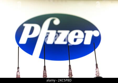 Foto-Illustration einer medizinischen Spritze mit einer Nadel, die vor dem Logo des Pharmakonzerns von Pfizer zu sehen ist. Großbritannien hat den Pfizer/BioNTech-Impfstoff zugelassen und eingeführt, während die FDA den COVID-19-Impfstoff für den Notfall in den USA zugelassen hat, wie von amerikanischen Medien berichtet wurde. Die Coronavirus-Pandemie, eine der größten Gesundheitskrisen der Welt, wird zu dem größten Impfprogramm in der menschlichen Geschichte führen. Amsterdam, Niederlande am 12. Dezember 2020 (Foto von Nicolas Economou/NurPhoto) Stockfoto