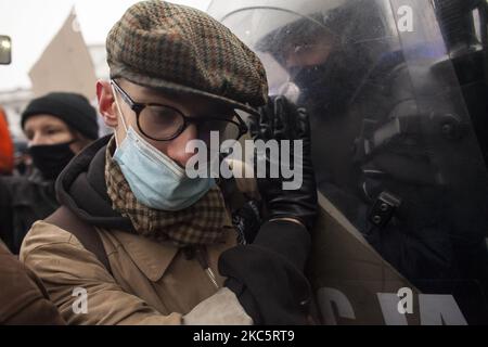 Protestler schiebt Polizeischutz während We Are Going for Freedom We Are Going for Everything Protest organisiert von Womens Strike und Anti-Lockdown-Unternehmern gegen die AIS-Regierung zum Jahrestag des Ausbruchs des kommunistischen Kriegsrechts in Warschau am 13. Dezember 2020. (Foto von Maciej Luczniewski/NurPhoto) Stockfoto