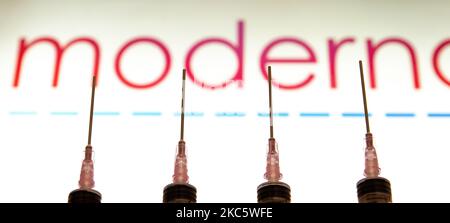 Foto-Illustration einer medizinischen Spritze mit einer Nadel vor dem Logo des Pharmakonzerns Moderna. Moderna erwartet die amerikanische Entscheidung, eine Zulassung für die Notfallverwendung, den Impfstoffkandidaten mRNA-1273 am 17 2020. Dezember von der FDA und die europäische Zulassung für den COVID-19-Impfstoff im Januar 2021. Moderna ist ein amerikanisches Biotechnologie-Unternehmen mit Sitz in Cambridge, Massachusetts, das Impfstofftechnologien auf Basis von Boten-RNA mRNA entwickelt. Die Coronavirus-Pandemie, eine der größten Gesundheitskrisen der Welt, wird zu dem größten Impfprogramm in der menschlichen Geschichte führen. Amste Stockfoto