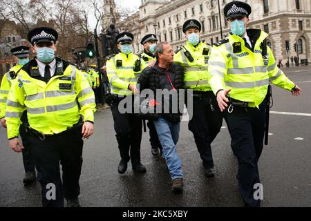 Ein Aktivist, der gegen die Sperren des Coronavirus und gegen jede vorgeschriebene Covid-19-Impfung protestiert, wird am 14. Dezember 2020 auf dem Parliament Square in London, England, von Polizisten verhaftet. Ab diesem Mittwoch soll London auf „Tier 3“-Beschränkungen umgestellt werden, was auf einen „sehr hohen“ Coronavirus-Alarm hinweist, der dazu führt, dass Pubs, Bars, Cafés und Restaurants geschlossen werden müssen, außer den Takeaway- und Lieferservice anzubieten. Die Stadt wurde am Ende der vierwöchigen Sperrung durch England am 2. Dezember wieder zu den „hohen“ Beschränkungen der Stufe 2 zurückgebracht, allerdings mit einigen strengenderen Bestimmungen Stockfoto