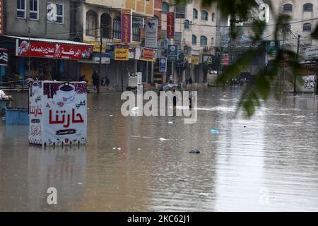 Am 17. Dezember 2020 werden Palästinenser in überschwemmten Straßen während heftiger Regenfälle im Lager Jabalia im nördlichen Gazastreifen gesehen. (Foto von Majdi Fathi/NurPhoto) Stockfoto