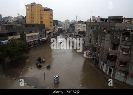 Am 17. Dezember 2020 werden Palästinenser in überschwemmten Straßen während heftiger Regenfälle im Lager Jabalia im nördlichen Gazastreifen gesehen. (Foto von Majdi Fathi/NurPhoto) Stockfoto