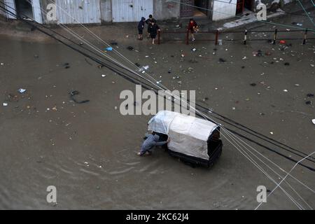 Am 17. Dezember 2020 werden Palästinenser in überschwemmten Straßen während heftiger Regenfälle im Lager Jabalia im nördlichen Gazastreifen gesehen. (Foto von Majdi Fathi/NurPhoto) Stockfoto