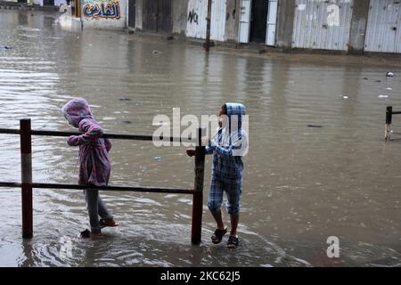 Am 17. Dezember 2020 werden Palästinenser in überschwemmten Straßen während heftiger Regenfälle im Lager Jabalia im nördlichen Gazastreifen gesehen. (Foto von Majdi Fathi/NurPhoto) Stockfoto