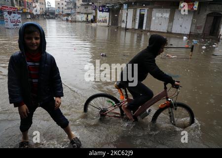 Am 17. Dezember 2020 werden Palästinenser in überschwemmten Straßen während heftiger Regenfälle im Lager Jabalia im nördlichen Gazastreifen gesehen. (Foto von Majdi Fathi/NurPhoto) Stockfoto