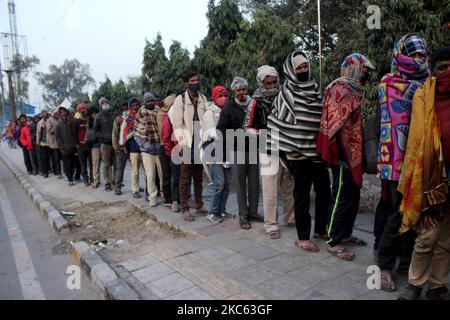 Obdachlose, die in Decken gehüllt sind, stehen am 17. Dezember 2020 an einem kalten Winterabend in Neu-Delhi, Indien, auf einem Bürgersteig in der Nähe eines Schutzheims am Kashmiri-Tor für kostenlose Mahlzeiten an. Laut Prognosen des Regionalen Meteorologischen Zentrums (RMC) in Delhi wird die Hauptstadt voraussichtlich vom 16. Bis 18. Dezember die Bedingungen der kalten Welle erleben. (Foto von Mayank Makhija/NurPhoto) Stockfoto