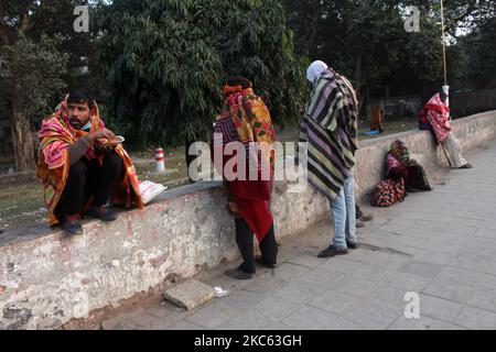 Obdachlose, die in Decken gehüllt sind, essen am 17. Dezember 2020 an einem kalten Winterabend in Neu-Delhi, Indien, auf einem Bürgersteig in der Nähe eines Schutzheims am Kashmiri-Tor. Laut Prognosen des Regionalen Meteorologischen Zentrums (RMC) in Delhi wird die Hauptstadt voraussichtlich vom 16. Bis 18. Dezember die Bedingungen der kalten Welle erleben. (Foto von Mayank Makhija/NurPhoto) Stockfoto