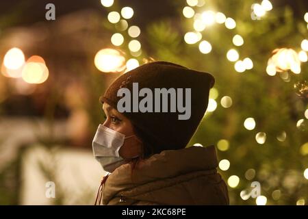 Ein Mädchen in einer Schutzmaske in der Nähe der Jahresbeleuchtung im Zentrum von St. Petersburg, Russland, am 20. Dezember 2020. Die Zahl der Fälle von Coronavirus in St. Petersburg überstieg 140 Tausend Menschen (Foto: Valya Egorshin/NurPhoto) Stockfoto