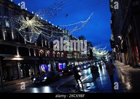 Am 21. Dezember 2020 hängen Weihnachtslichter über einer fast menschenleeren Regent Street in London, England. London verbrachte heute seinen zweiten Tag, der möglicherweise Monate unter den neu eingeführten „Tier 4“-Coronavirus-Beschränkungen sein könnte. Nach den Regeln der Stufe 4 müssen nicht unbedingt erforderliche Geschäfte und viele andere Unternehmen, einschließlich Fitnessstudios und Friseure, schließen, wobei die Leute angewiesen werden, sich außerhalb von ausgenommenen Umständen wie Reisen zur Arbeit oder zur Ausbildung zu Hause zu halten. Auch das Vermischen in Innenräumen zwischen Menschen in verschiedenen Haushalten ist unter der neuen Stufe verboten, was die Weihnachtspläne für einen großen Teil der Bevölkerung aufwirft. Sorge OV Stockfoto