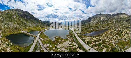 Eine schöne Aussicht auf den Gotthard Pass in der Schweiz mit grünen Hügeln unter einem hellen bewölkten Himmel Stockfoto