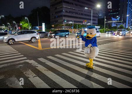 Ein Mann, der am 24. Dezember 2020 im Central Business District in Jakarta als Donald Duck gekleidet war. Jeden Abend trägt Jimmy Wuri ein Donald Duck Kostüm, um die Menschen auf der Straße zu unterhalten. Jimmy wurde aufgrund der Pandemie im Juli von einem Export- und Importunternehmen entlassen. Unter Verwendung der verbleibenden Abfindungszahlung kaufte Jimmy ein Donald Duck Kostüm für 1.500.000 IDR (106 USD). Er lief 15 Kilometer und spielte lustig, um die Leute zu unterhalten, er bat nie um Geld. An einem Tag erhält Jimmy 100.000 IDR (7 USD) von Menschen, die von seinen Handlungen unterhalten werden. Das Geld wird verwendet, um eine Miete für Häuser in einem Slum zu zahlen Stockfoto