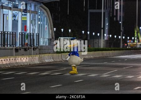 Ein Mann, der am 24. Dezember 2020 im Central Business District in Jakarta als Donald Duck gekleidet war. Jeden Abend trägt Jimmy Wuri ein Donald Duck Kostüm, um die Menschen auf der Straße zu unterhalten. Jimmy wurde aufgrund der Pandemie im Juli von einem Export- und Importunternehmen entlassen. Unter Verwendung der verbleibenden Abfindungszahlung kaufte Jimmy ein Donald Duck Kostüm für 1.500.000 IDR (106 USD). Er lief 15 Kilometer und spielte lustig, um die Leute zu unterhalten, er bat nie um Geld. An einem Tag erhält Jimmy 100.000 IDR (7 USD) von Menschen, die von seinen Handlungen unterhalten werden. Das Geld wird verwendet, um eine Miete für Häuser in einem Slum zu zahlen Stockfoto