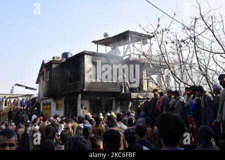 Menschen in Kashmiri beurteilen das beschädigte Wohnhaus im Dorf Kanigam im Bezirk Shopian, südlich von Srinagar, im indischen Kaschmir, am 26. Dezember 2020. Bei einem nächtlichen Treffen wurden zwei lokale kashmiritische Millitanten getötet und zwei indische paramilitärische Truppen verletzt. (Foto von Muzamil Mattoo/NurPhoto) Stockfoto