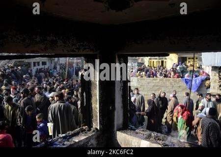 Menschen in Kashmiri beurteilen das beschädigte Wohnhaus im Dorf Kanigam im Bezirk Shopian, südlich von Srinagar, im indischen Kaschmir, am 26. Dezember 2020. Bei einem nächtlichen Treffen wurden zwei lokale kashmiritische Millitanten getötet und zwei indische paramilitärische Truppen verletzt. (Foto von Muzamil Mattoo/NurPhoto) Stockfoto